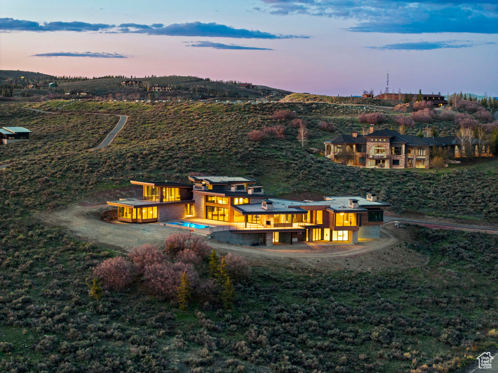 Back of property at dusk with a balcony