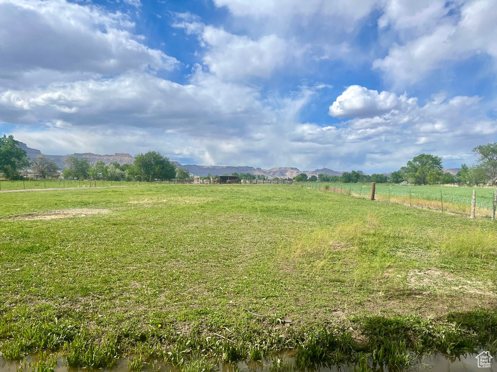 View of yard featuring a view of rural / pastoral area, a mountain view, and fence
