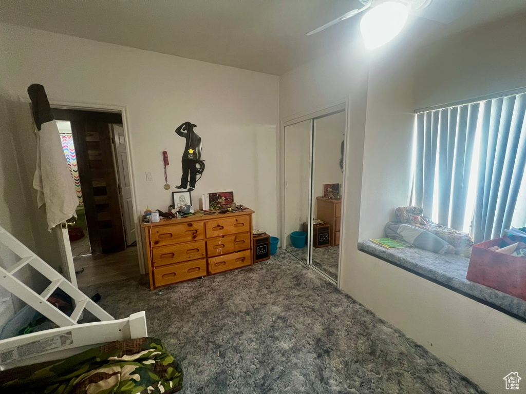 Bedroom featuring carpet, multiple windows, a closet, and a ceiling fan