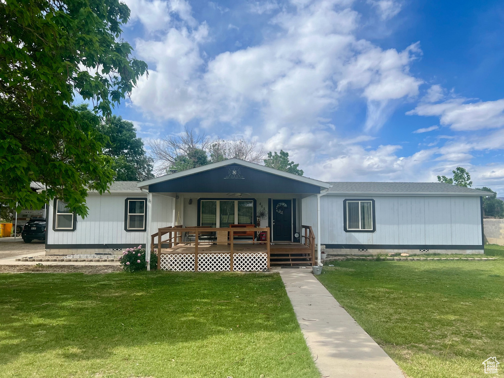 Manufactured / mobile home featuring covered porch, a front yard, and crawl space