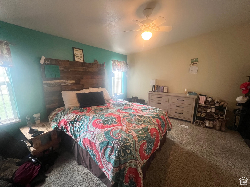 Carpeted bedroom with a ceiling fan