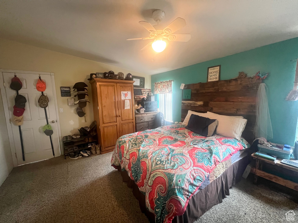 Carpeted bedroom with lofted ceiling and a ceiling fan
