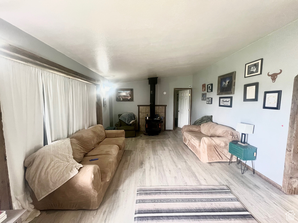 Living room featuring a wood stove and light wood-style flooring