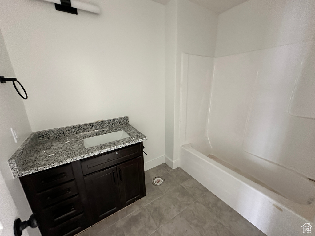 Full bathroom with vanity, tile patterned floors, tub / shower combination, and baseboards