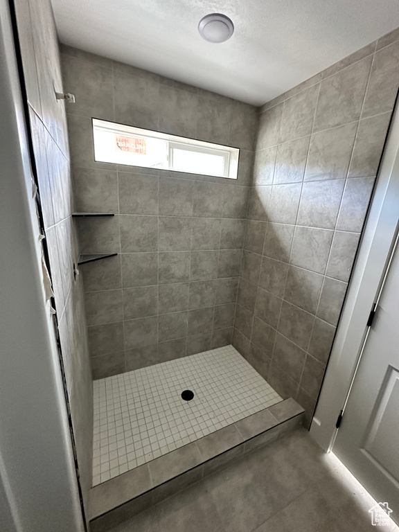 Bathroom with a tile shower and plenty of natural light