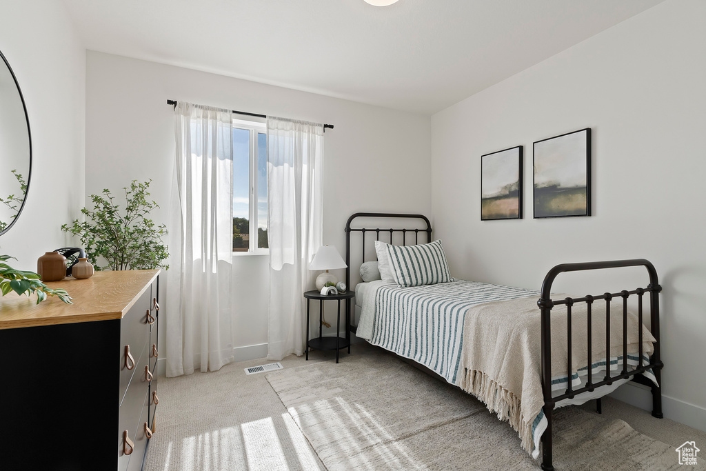 Bedroom with light carpet and baseboards