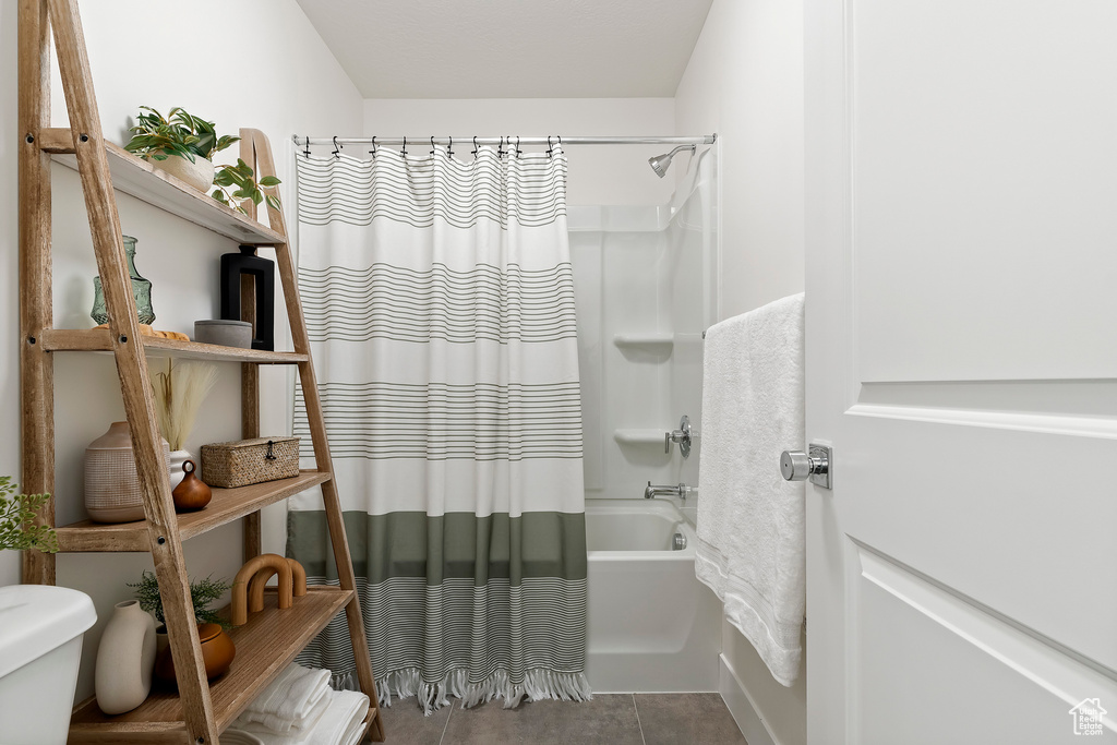 Bathroom featuring shower / tub combo and tile patterned flooring