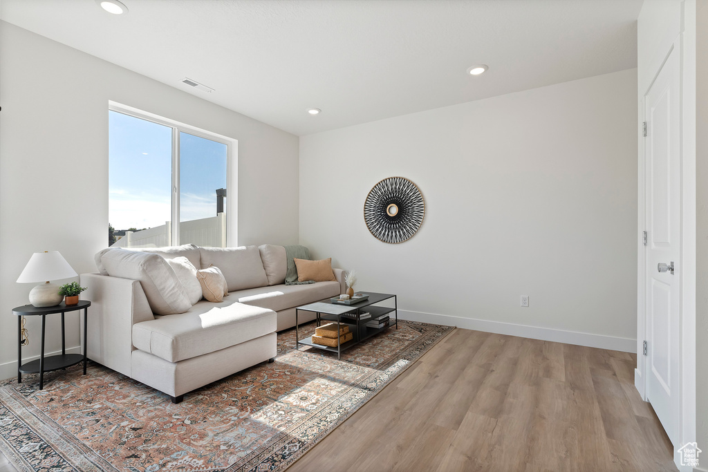 Living room featuring wood finished floors, baseboards, and recessed lighting