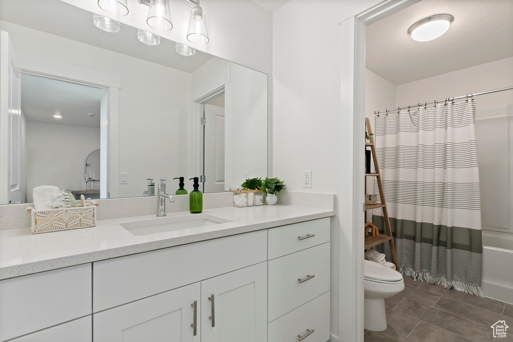 Bathroom featuring toilet, vanity, and shower / bath combo