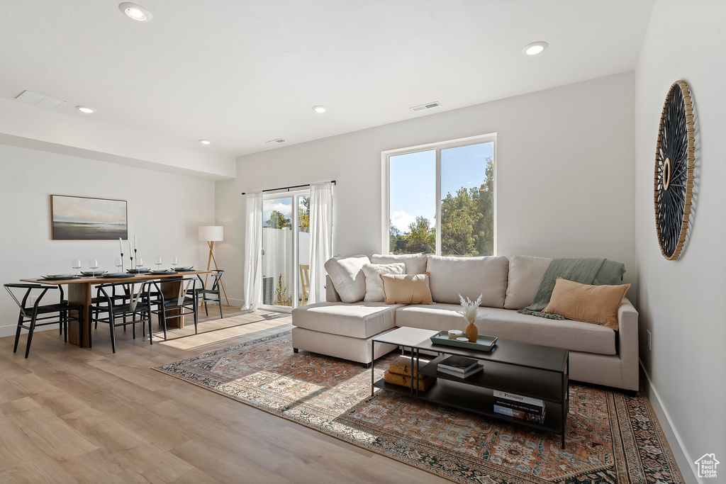Living room with baseboards, wood finished floors, and recessed lighting