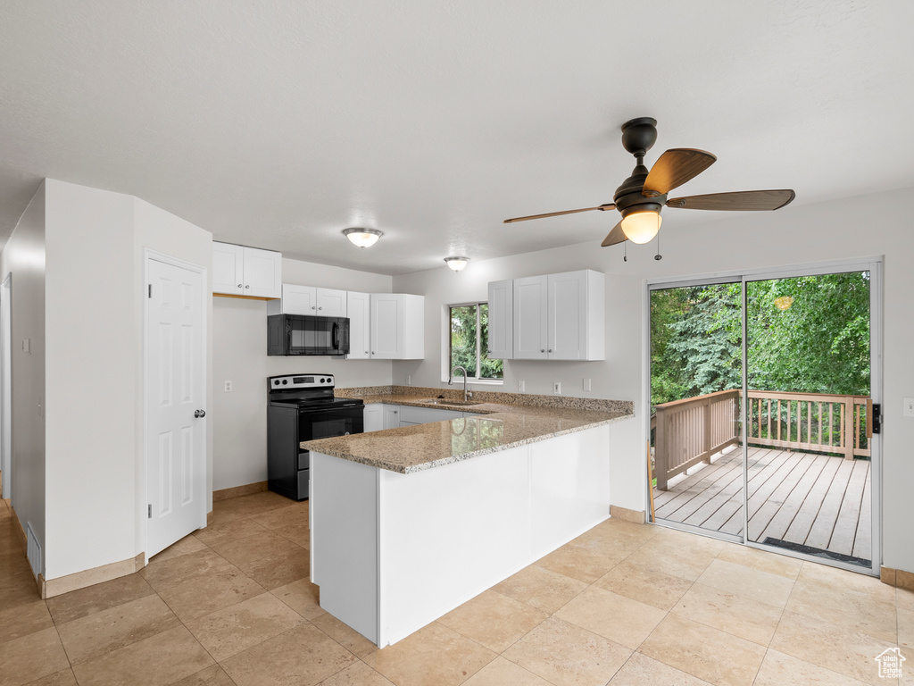 Kitchen featuring black appliances, a peninsula, ceiling fan, a sink, and white cabinets