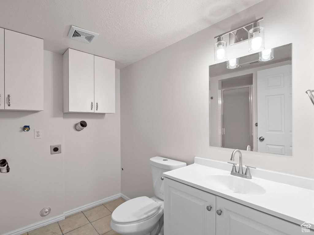 Bathroom featuring toilet, tile patterned floors, a shower with door, baseboards, and vanity