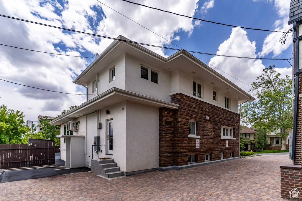 View of property exterior featuring stucco siding, fence, and entry steps
