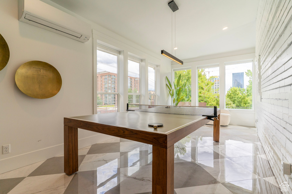 Playroom with an AC wall unit, plenty of natural light, baseboards, and recessed lighting