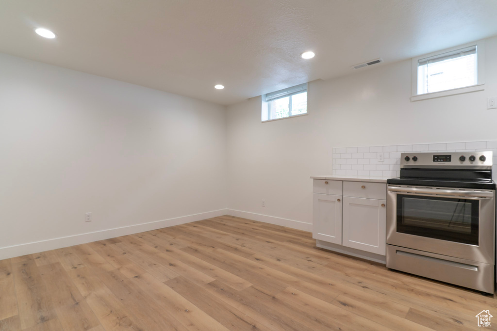 Kitchen featuring electric range, recessed lighting, light wood-style floors, white cabinets, and light countertops