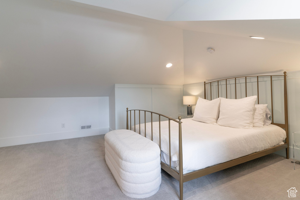 Carpeted bedroom featuring vaulted ceiling and recessed lighting