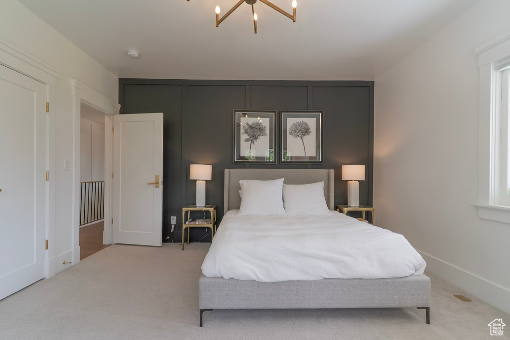 Carpeted bedroom featuring a chandelier