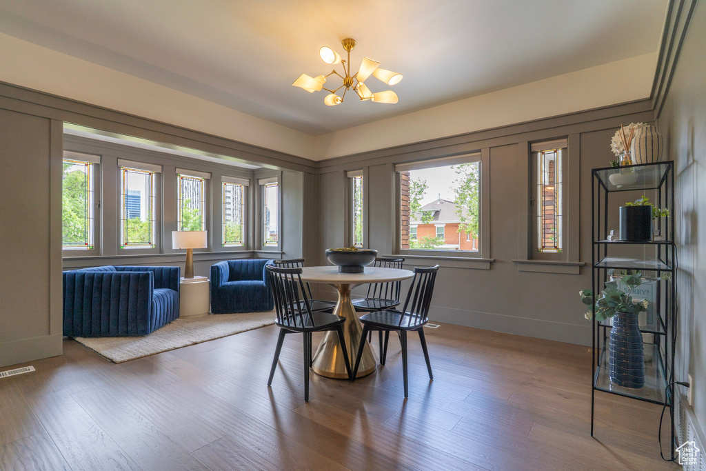 Dining room with a chandelier, wood finished floors, and baseboards