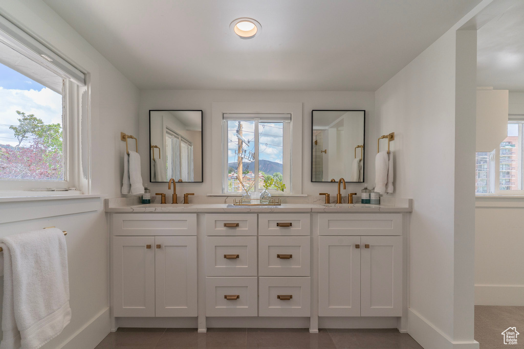 Bathroom with baseboards, double vanity, recessed lighting, and tile patterned flooring