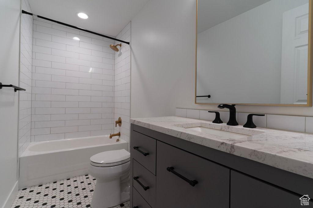 Bathroom featuring toilet, vanity, bathtub / shower combination, recessed lighting, and tile patterned floors