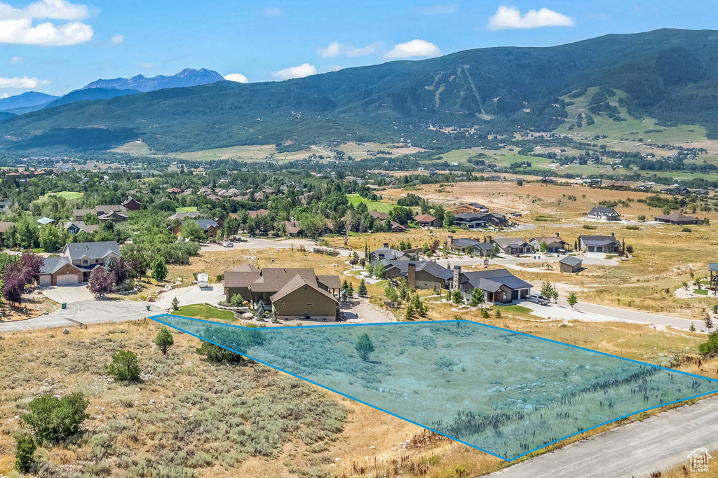 Aerial perspective of suburban area featuring a mountain backdrop and property boundaries highlighted