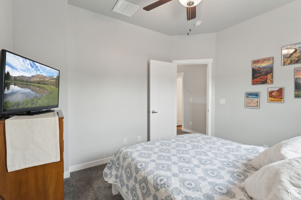 Carpeted bedroom featuring baseboards and ceiling fan