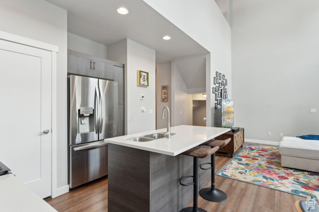 Kitchen featuring stainless steel fridge, modern cabinets, a sink, wood finished floors, and recessed lighting