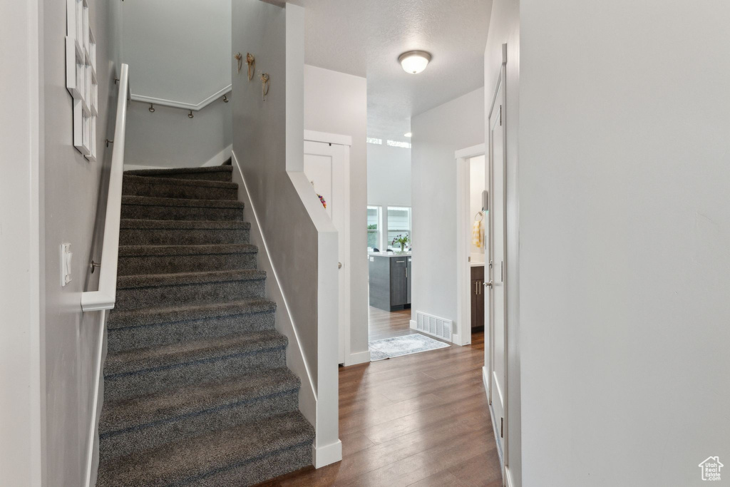 Stairs with wood finished floors and baseboards