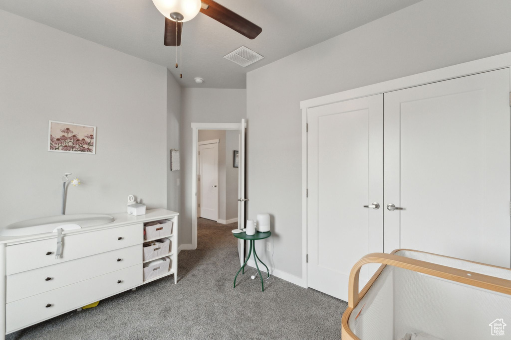 Bedroom featuring light colored carpet, a closet, baseboards, ceiling fan, and a sink