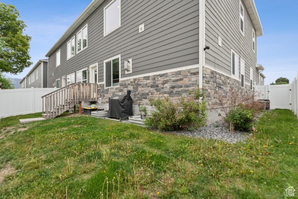 Rear view of property with stone siding and a gate
