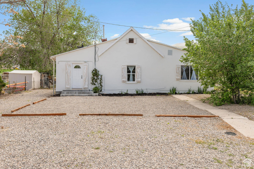 View of front of home featuring stucco siding and fence