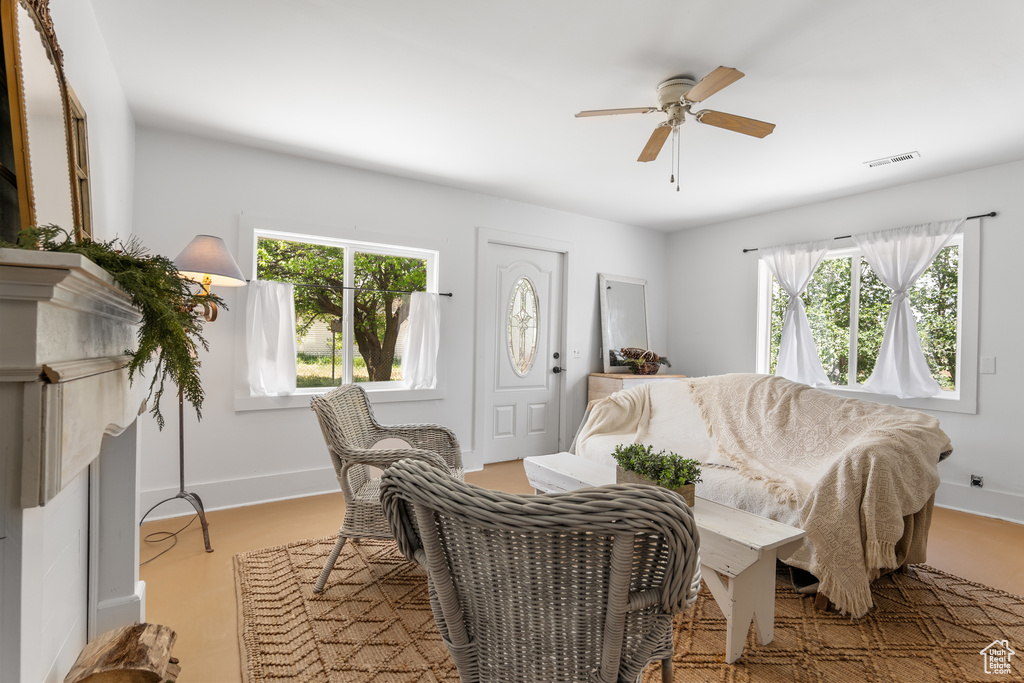 Living room featuring healthy amount of natural light, a ceiling fan, and baseboards