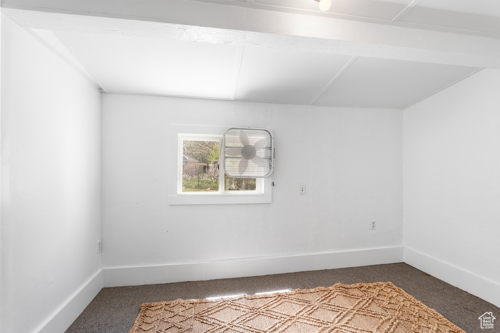 Spare room featuring dark carpet