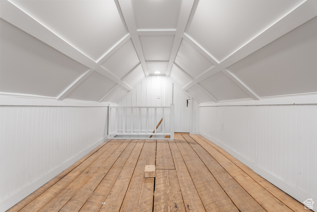 Bonus room featuring lofted ceiling, hardwood / wood-style flooring, and wooden walls