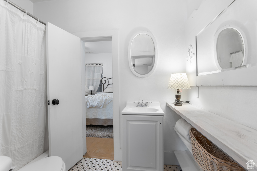 Full bathroom featuring toilet, vanity, tile patterned floors, and connected bathroom