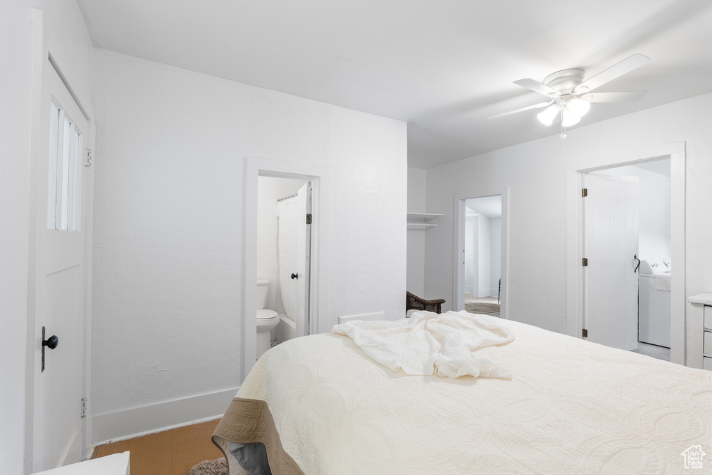 Bedroom with washer / dryer, wood finished floors, ensuite bathroom, and baseboards