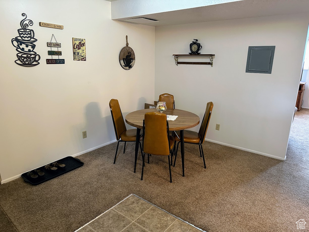 Dining room with carpet, baseboards, and electric panel