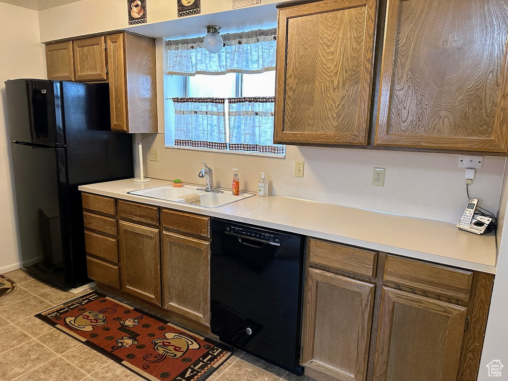Kitchen with black appliances, a sink, and light countertops