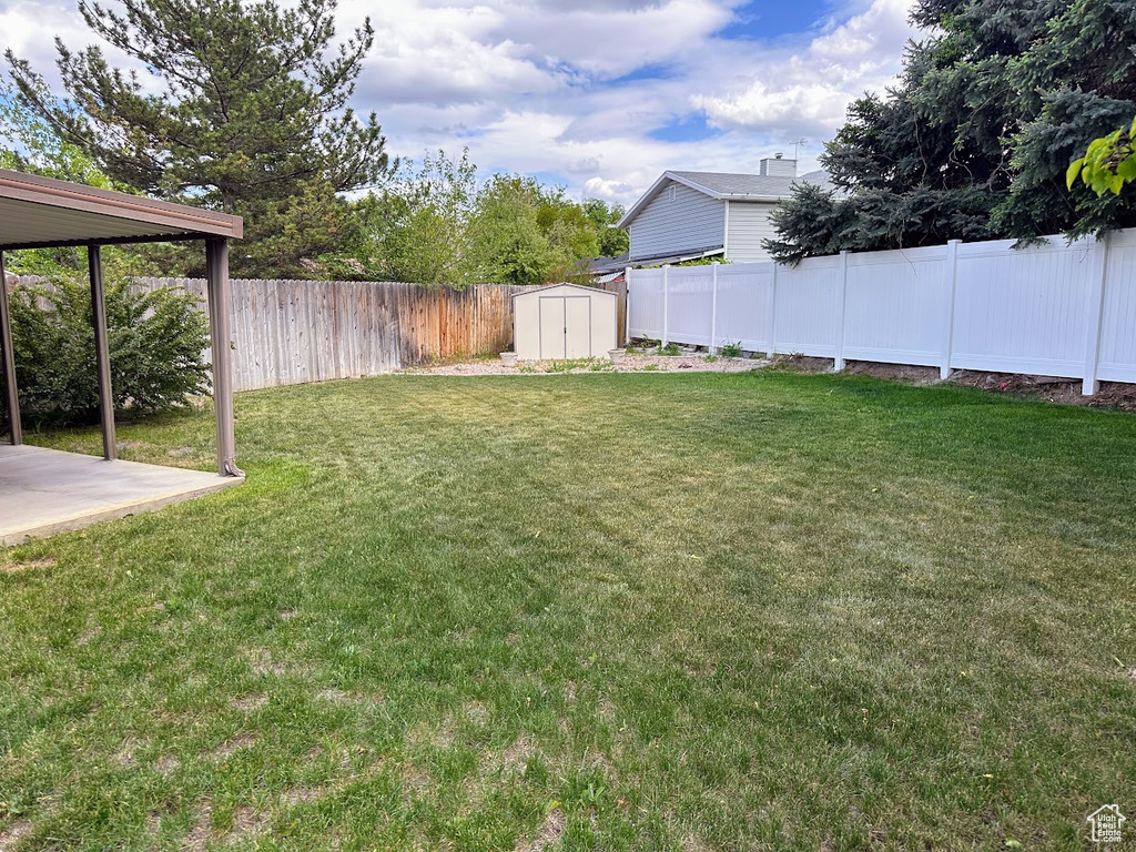 View of yard featuring a shed, an outdoor structure, and a patio area