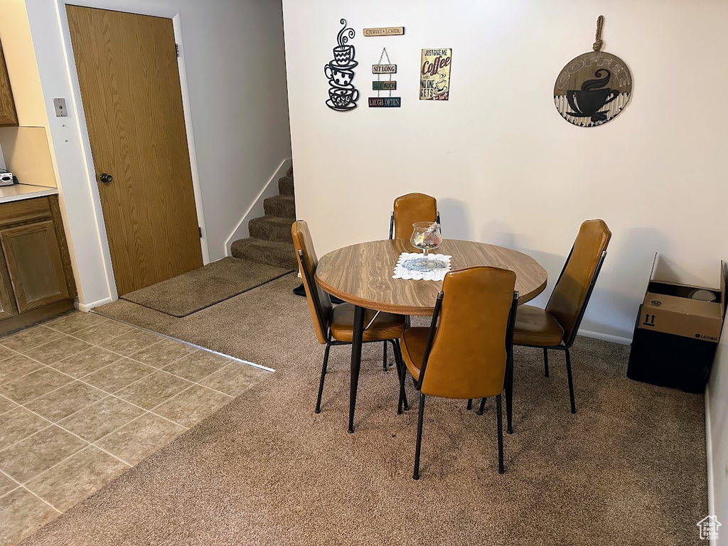 Dining space with stairs, carpet flooring, and baseboards