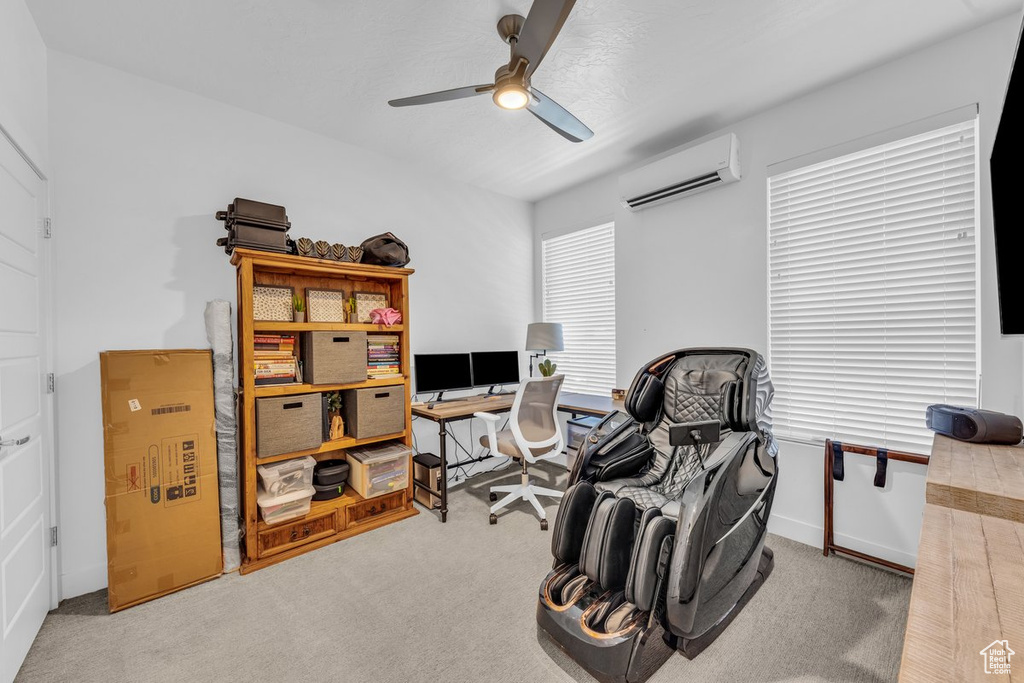 Office space with a wall unit AC, carpet flooring, ceiling fan, and baseboards