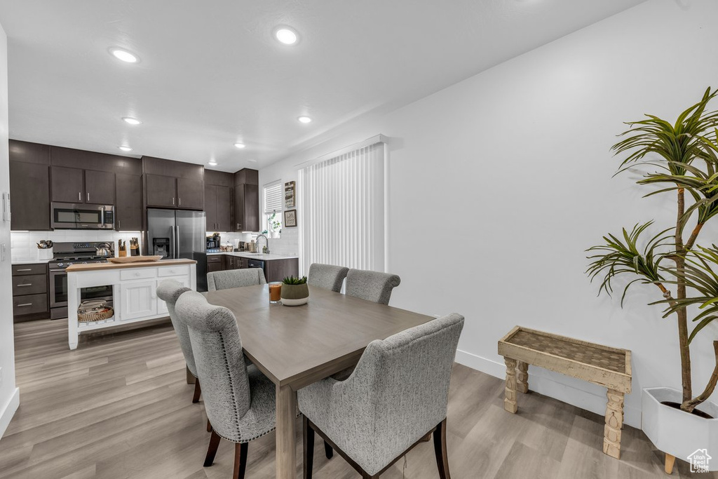 Dining room with light wood-style floors, recessed lighting, and baseboards