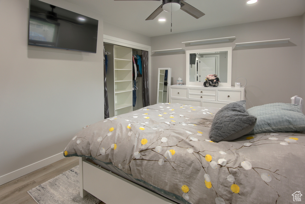 Bedroom with light wood finished floors, baseboards, a closet, recessed lighting, and a ceiling fan