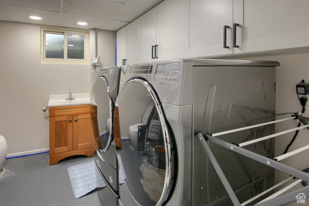 Clothes washing area with independent washer and dryer, a sink, and recessed lighting