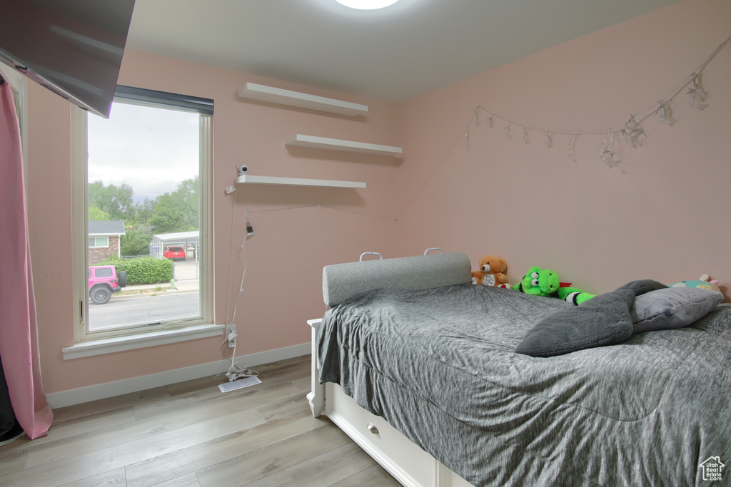 Bedroom with light wood finished floors and baseboards