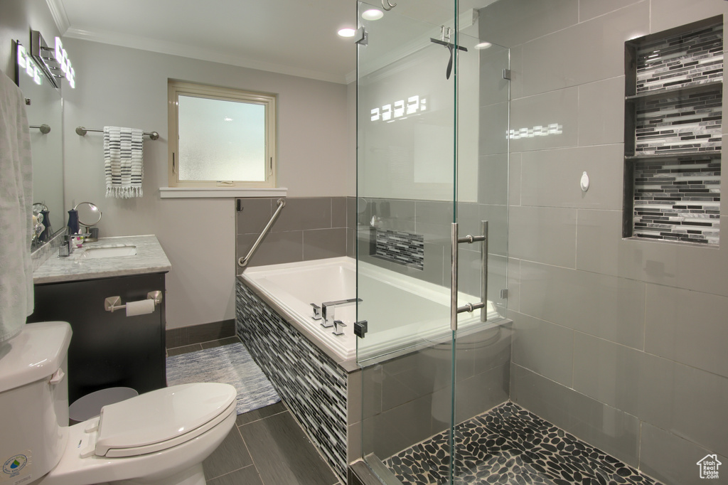 Full bathroom with toilet, ornamental molding, a shower stall, a garden tub, and vanity