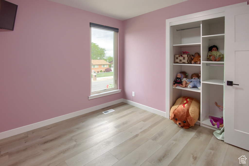 Unfurnished bedroom with light wood-style floors and baseboards