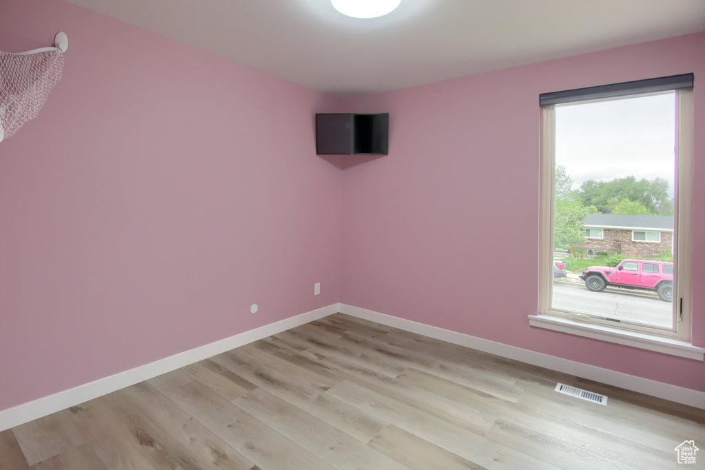 Spare room featuring light wood finished floors and baseboards