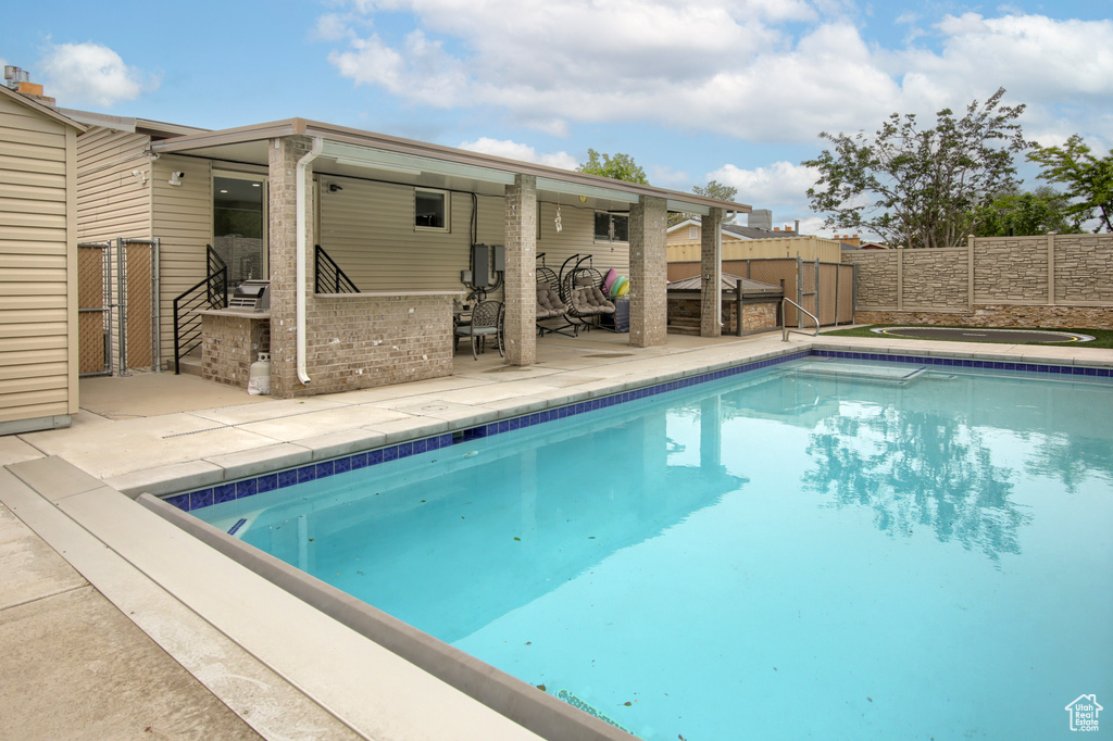 View of swimming pool featuring a fenced backyard and a patio