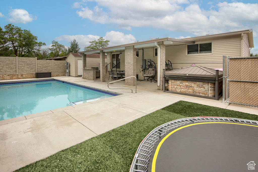 View of swimming pool with a patio and a fenced backyard